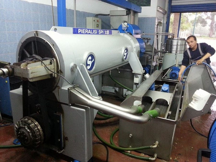 man worker at Elladiko plant with olive oil equipment